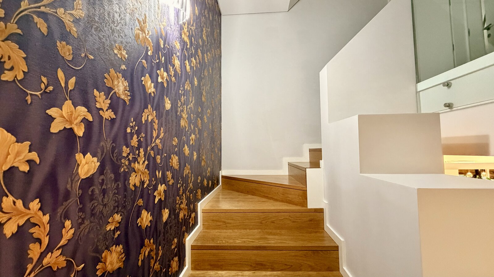 Escadas interiores com papel de parede floral dourado