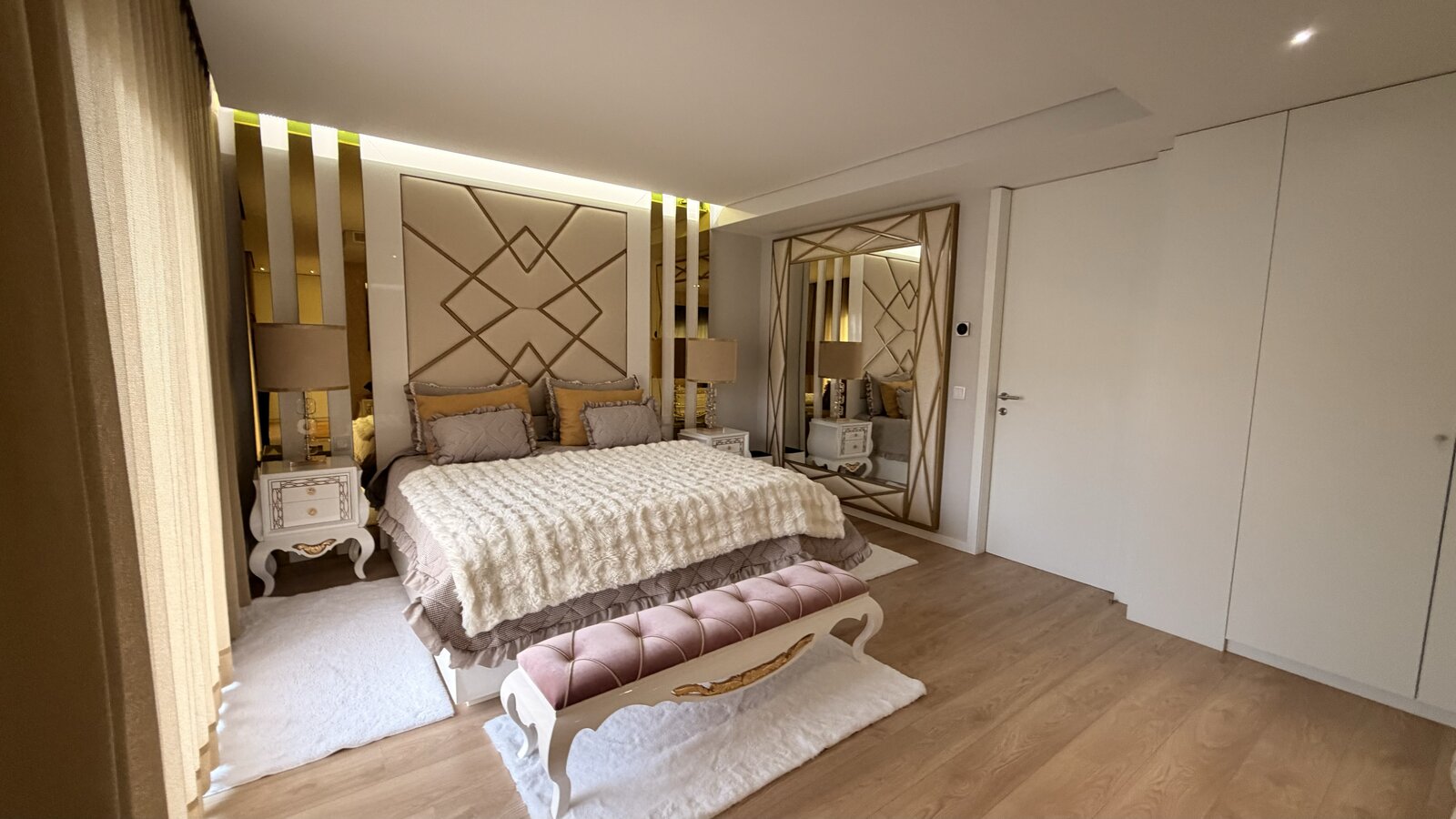 Quarto com espelho e cabeceira dourada
